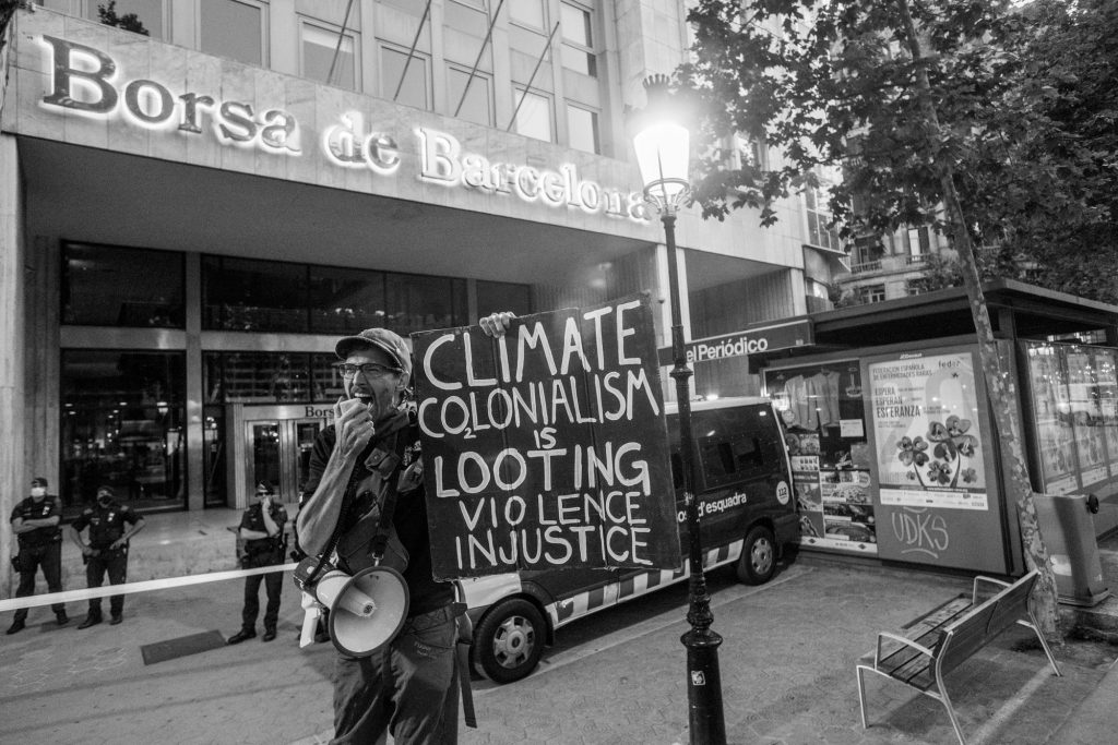 Rebelde con cartel ante La Bolsa de Barcelona el Día del Medio Ambiente